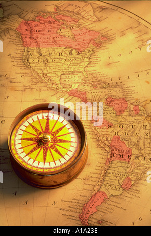 Still life of a compass sitting on an old map of North and South America Stock Photo