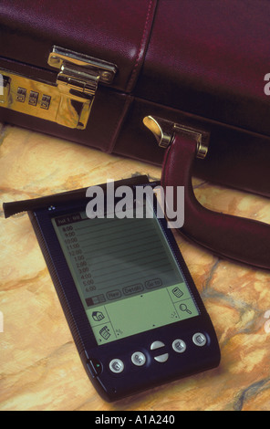 Still life of an electronic personal data organizer and a briefcase Stock Photo