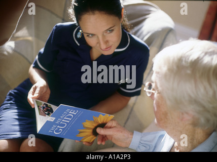 district nurse visiting elderly woman at her home Stock Photo