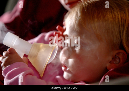 A child uses a nebulizer for her asthma. Stock Photo