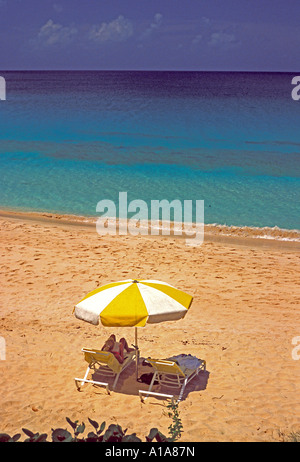 Anguilla beach couple umbrella on Mead's Bay beach Stock Photo