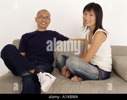 Asian couple on sofa Stock Photo
