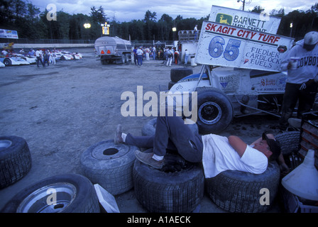 USA Washington Sedro Woolley Young man naps on sprint cars racing tire in pits at Skagit Speedway Stock Photo