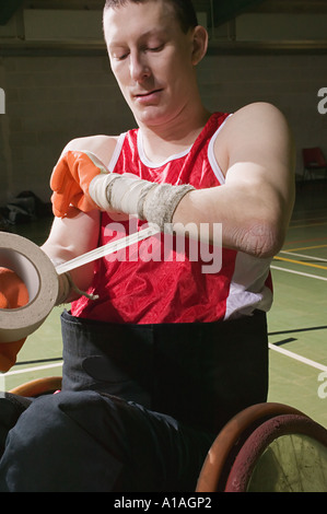 Quad rugby player bandaging his arm Stock Photo
