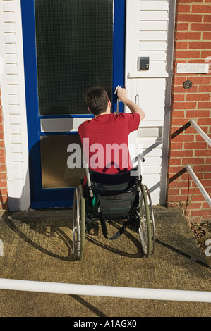 Disabled man opening his front door Stock Photo