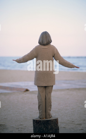 Senior woman balancing on a log Stock Photo