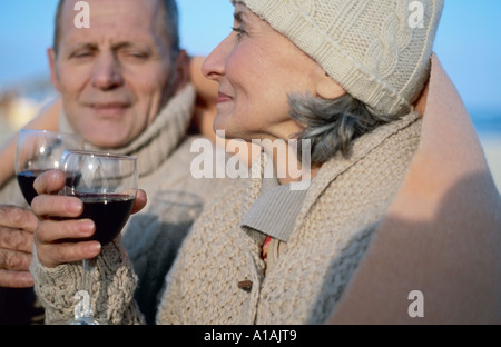 Senior couple drinking wine in blanket Stock Photo