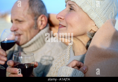 Senior couple drinking wine in blanket Stock Photo