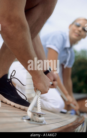 Couple on boat securing a rope Stock Photo