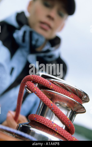 Woman winding rope around crank Stock Photo