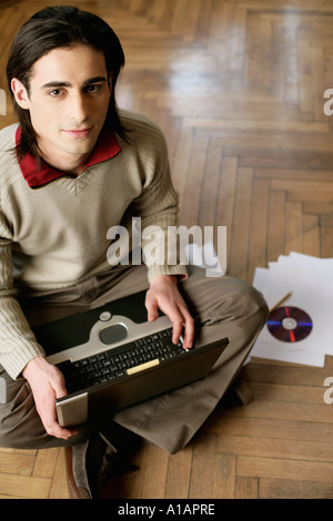 Man sitting on the floor with laptop Stock Photo
