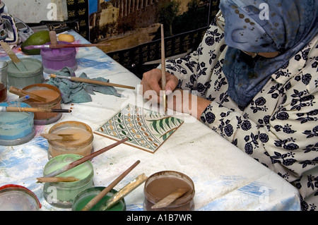 A Palestinian woman paints a ceramic tile in an Armenian tile workshop in East Jerusalem Israel Stock Photo