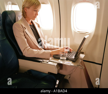 Woman with laptop on plane Stock Photo