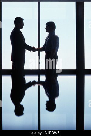 Two Executives with Opposing Views Shaking Hands and Closing the Deal Stock Photo