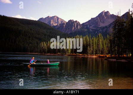 A mother and her 3 year old son canoe on a placid lake in the Idaho mountains Stock Photo