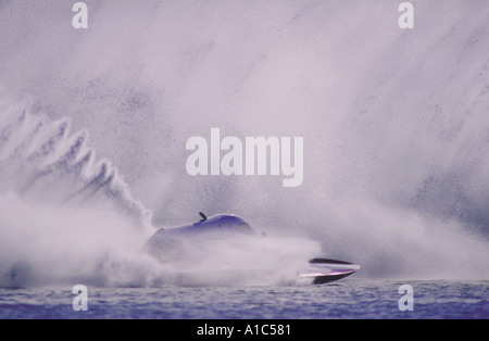 Hydroplane boat in front of a huge wall of waterspray generated by other boats in a professional powerboat race Stock Photo