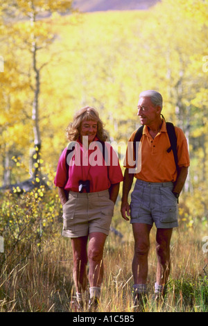 Senior couple walking in autumn woods Stock Photo