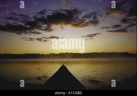 Front of canoe pointing toward far side of lake seconds before sunrise Taken on Sabbathday Lake in Maine Stock Photo