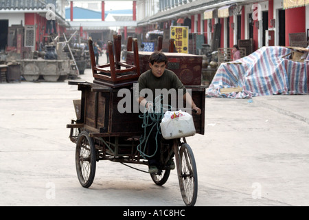 bicycle cart is used to haul furniture around the antique market in zhongshan, China Stock Photo