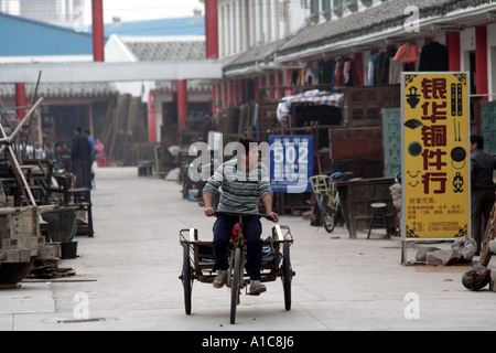 bicycle cart is used to haul furniture around  the antique market in zhongshan, China Stock Photo