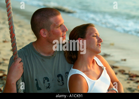 Young couple embrace on swing Teluk Nipah beach Pulau Pangkor island Malaysia Stock Photo