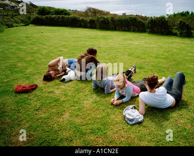 Young women sunbathing on lawn Stock Photo