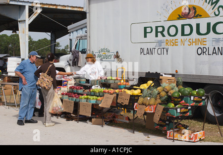 Produce vendor completing sale of fruits and vegetables from truck at flea market in Eustis, Florida, USA Stock Photo