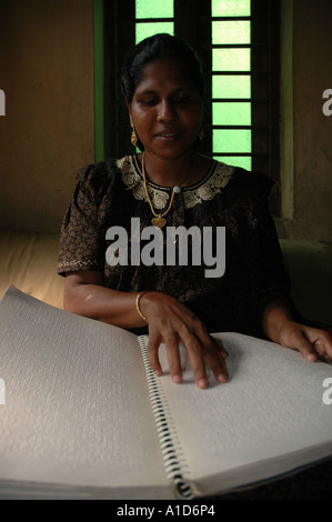 A blind woman reads braille in her home in southern Tamil Nadu India Stock Photo