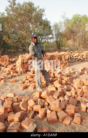 Worker with bricks made from a termite mound in Zambia Stock Photo