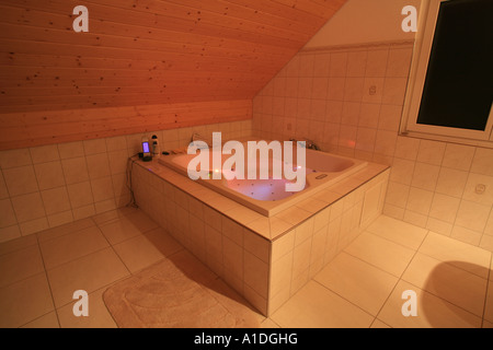 Jacuzzi tub with remote control and colored lights in a white bathroom Stock Photo