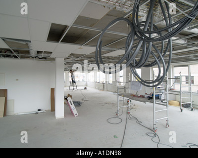 A modern office space has lot and lots of cables running through the ceiling Stock Photo