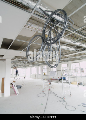A modern office space has lot and lots of cables running through the ceiling Stock Photo