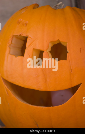 Close-up of a smiling Halloween pumpkin with one round eye and one square eye carved into its orange skin for a spooky holiday decoration. Stock Photo