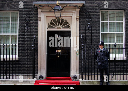 Armed policeman guards Number 10 Downing Street the home of the British Prime Minister London United Kingdom Stock Photo