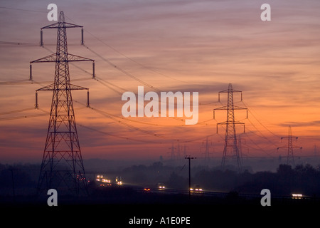 Electricity pylons over a motorway near Burbage Leicestershire United Kingdom Stock Photo