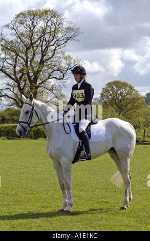 Young man on grey mare horse prepares to ride dressage at eventing competition Oxfordshire United Kingdom Stock Photo