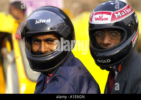 Two men businessmen in tie suit and safety motorbike helmet, street portrait on rickshaw background in New Delhi, India Stock Photo