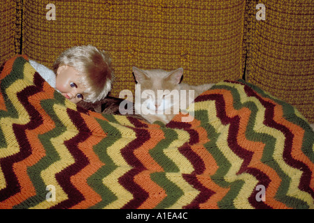 A cat and a doll make happy bedfellows Stock Photo