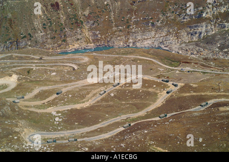 Military trucks at twisted road in Rohtang pass at the side of Lahaul Valley, Indian Himalaya mountains Stock Photo