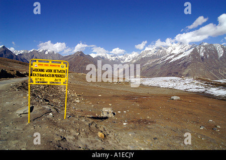 Twisted road with yellow sign in Rohtang pass at the side of Lahaul Valley, Indian Himalaya mountains Stock Photo