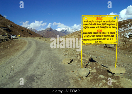 Twisted road with yellow sign in Rohtang pass at the side of Lahaul Valley, Indian Himalaya mountains Stock Photo