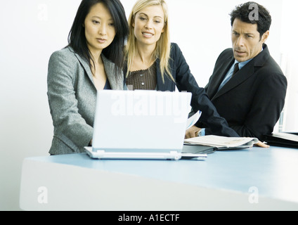 Businesspeople working on laptop together Stock Photo