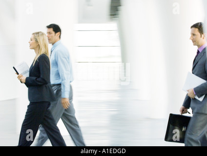 Businesspeople walking through lobby Stock Photo