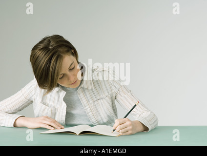 Young woman writing in notebook Stock Photo