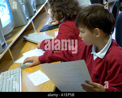 School computer class boy Junior schoolboy working on his computer terminal in school computer classroom Stock Photo