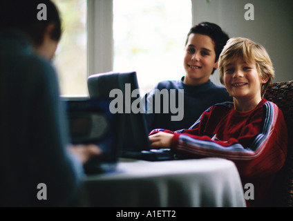 Two children using laptop and smiling Stock Photo