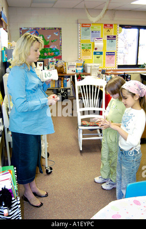 Pregnant woman teacher conducts lessons in her third grade classroom Stock Photo