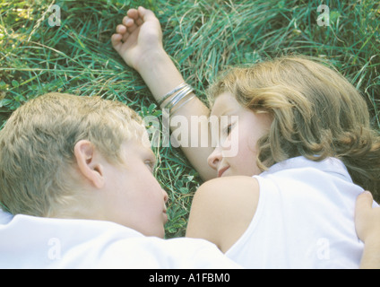 Boy and girl lying in grass Stock Photo