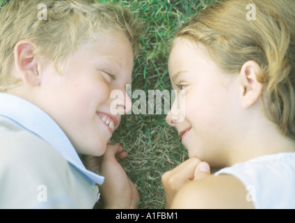 Boy and girl lying in grass, smiling Stock Photo