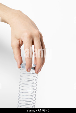 Hand holding metal coil toy Stock Photo